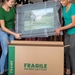 two women placing frame into frame moving box